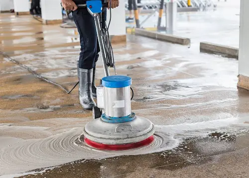 Personne nettoyant un sol avec une monobrosse